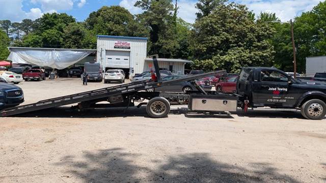 Jolad Towing rollback truck loaded with a vehicle